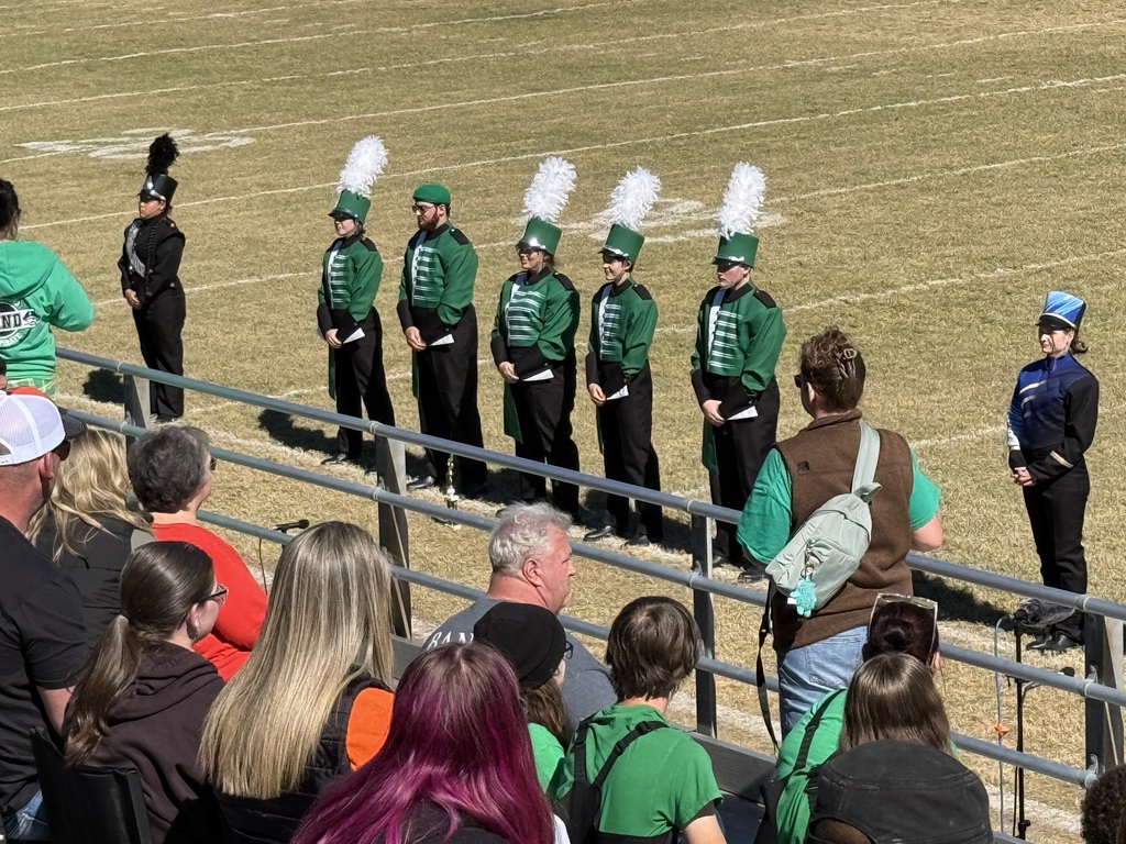 seven band members standing on the field in front of a crowd