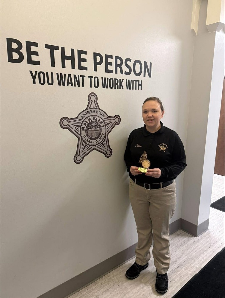Female standing with award with sign that says 'be the peron you want to work with"