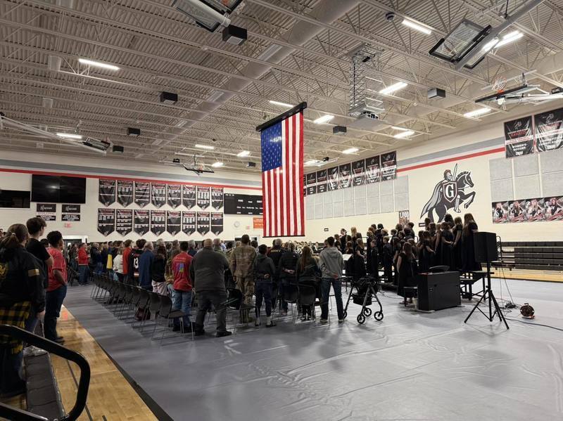 Gym full of hundreds of students and veterans and an army jeep