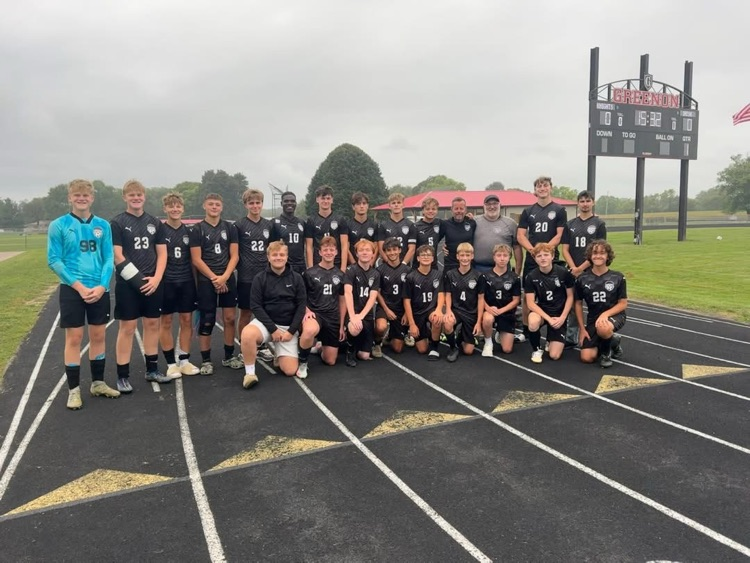 soccer team in black jerseys standing for photo