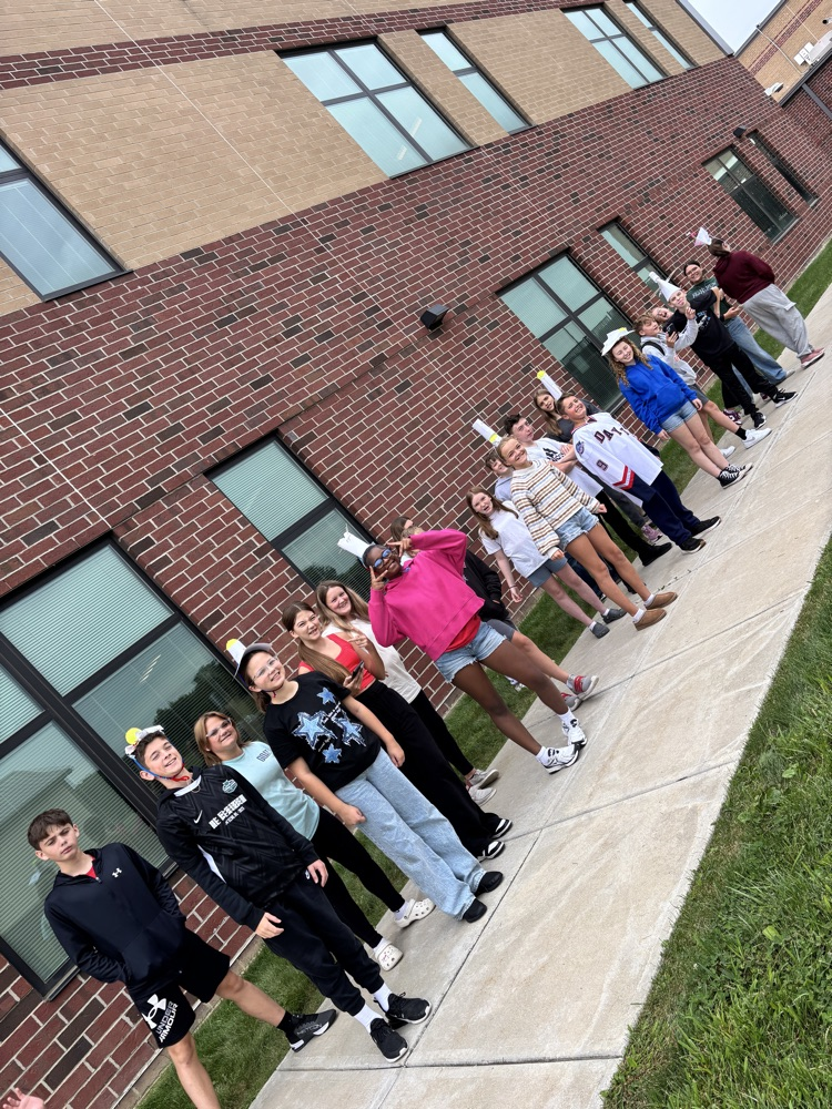 student in a group with apples on their head