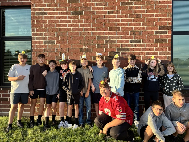 student group standing with apples on head