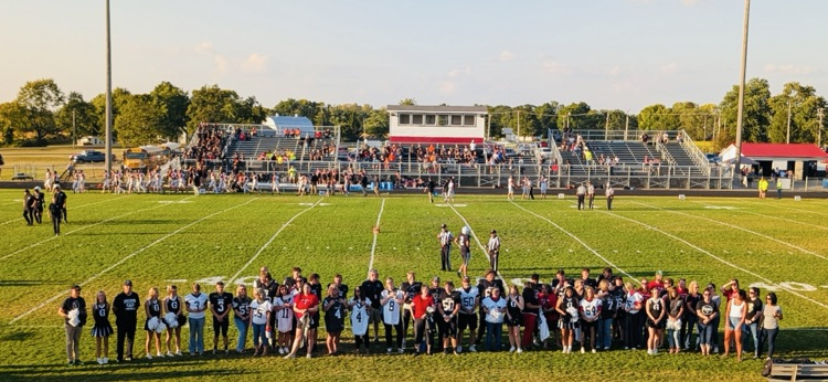 large group of players and teachers on the field 