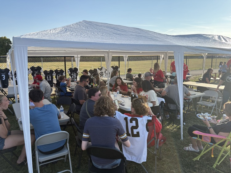 group of families eating under tents