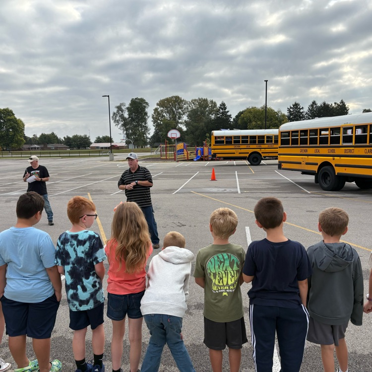 students lined up looking at bus
