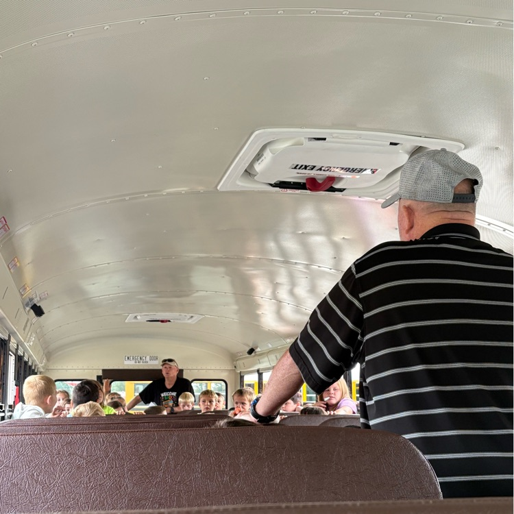 students inside bus with adults talking 