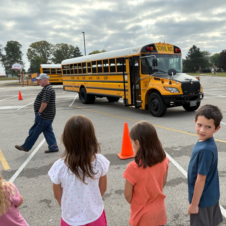 students lined up looking at bus
