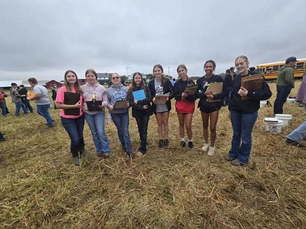 Students standing in fields with clipboards