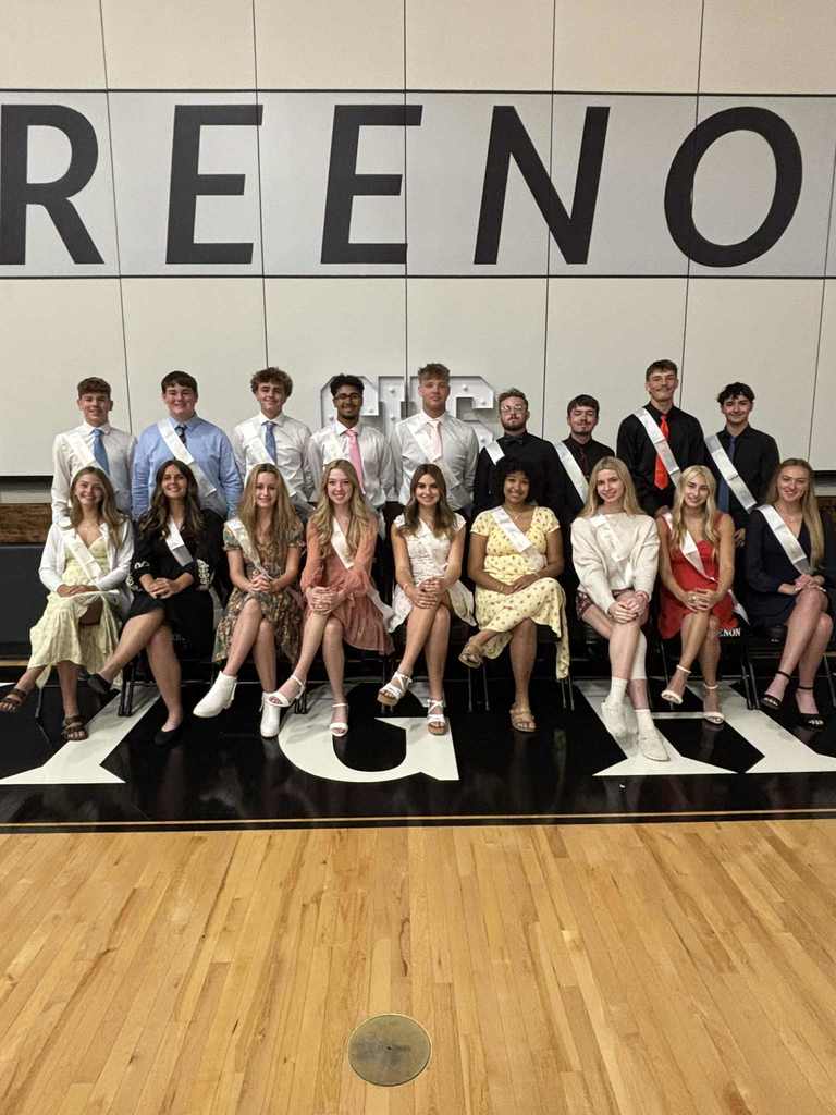 Group of female students sitting in front of male students dressed up on homecoming court
