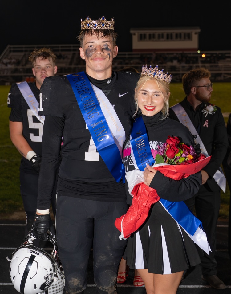 girl in cheer inform with crown and boy in football uniform in crown