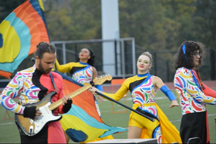 color guard members and band members playing guitar