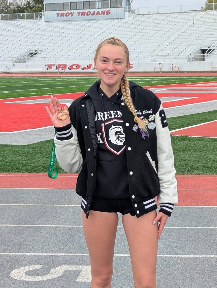 female runner standing with medal