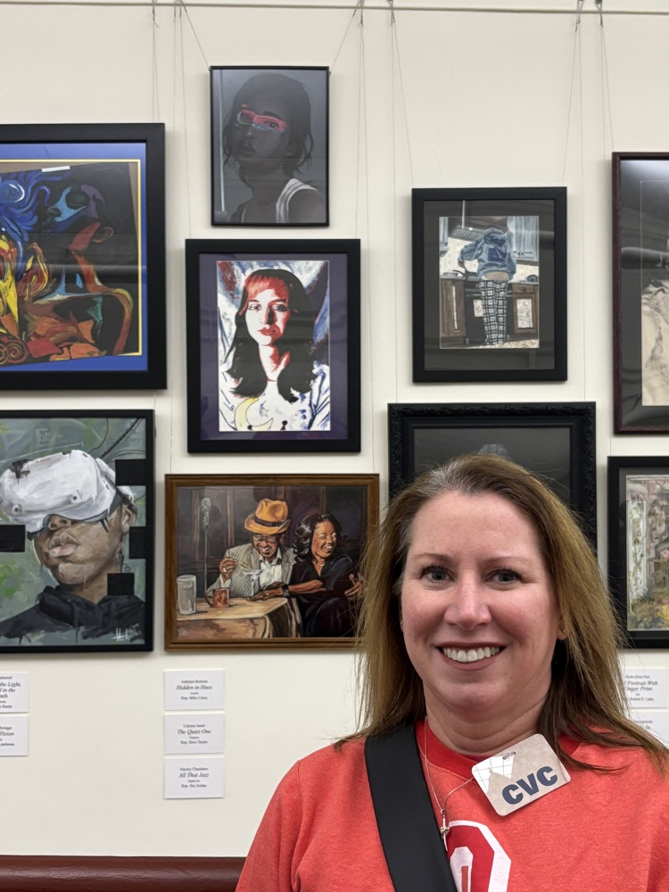 lady standing in front of artwork with red sweatshirt