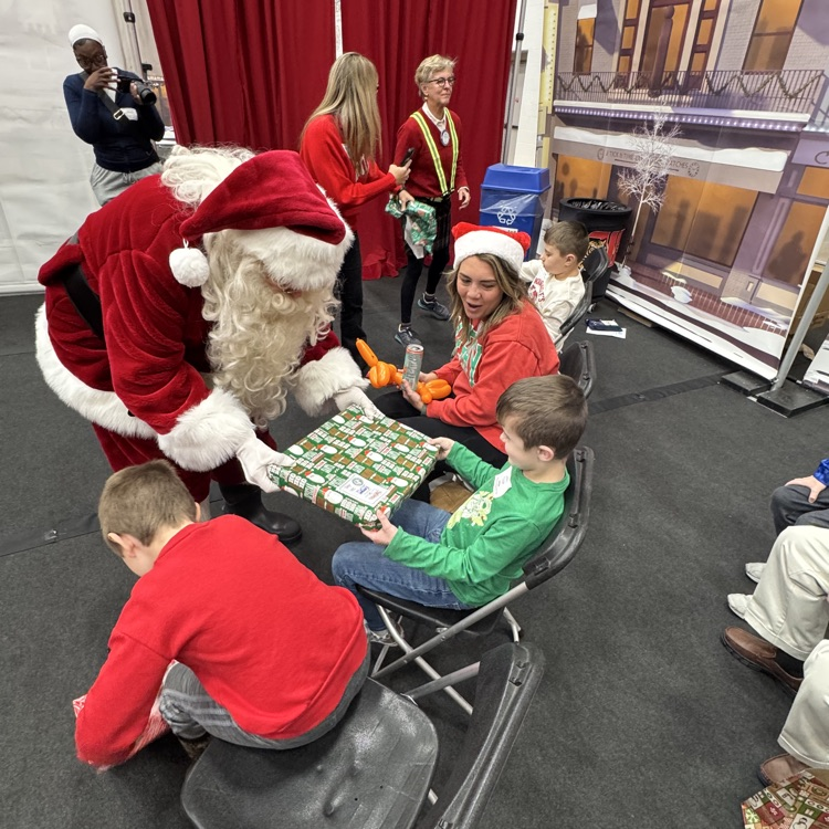 students at Christmas party with Santa giving gift