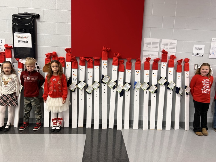 students standing with wooden snowmen