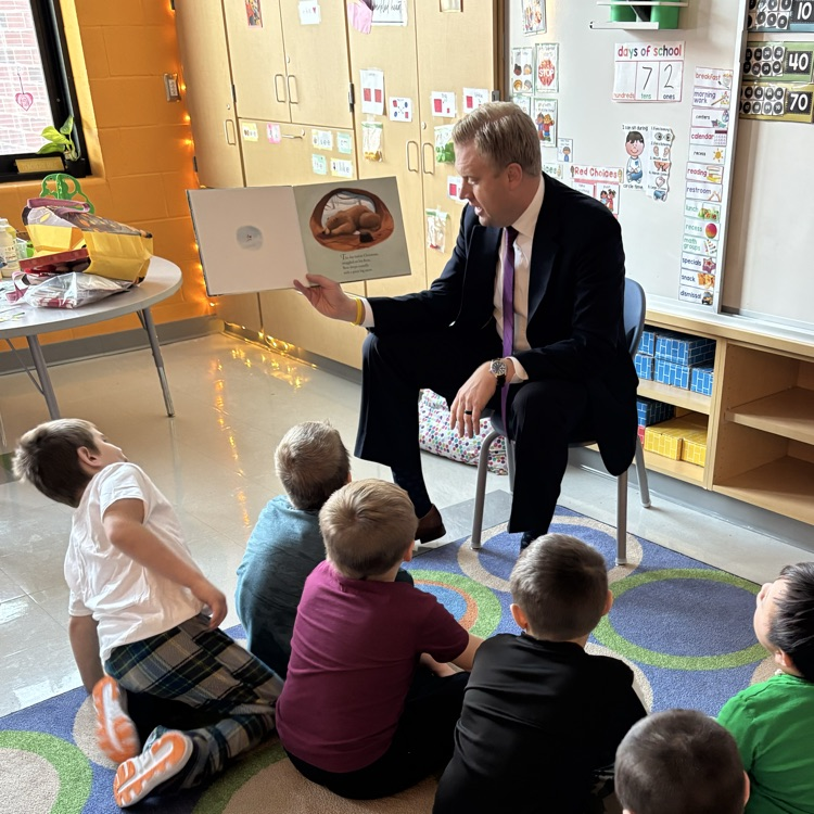 children being read to on a carpet 