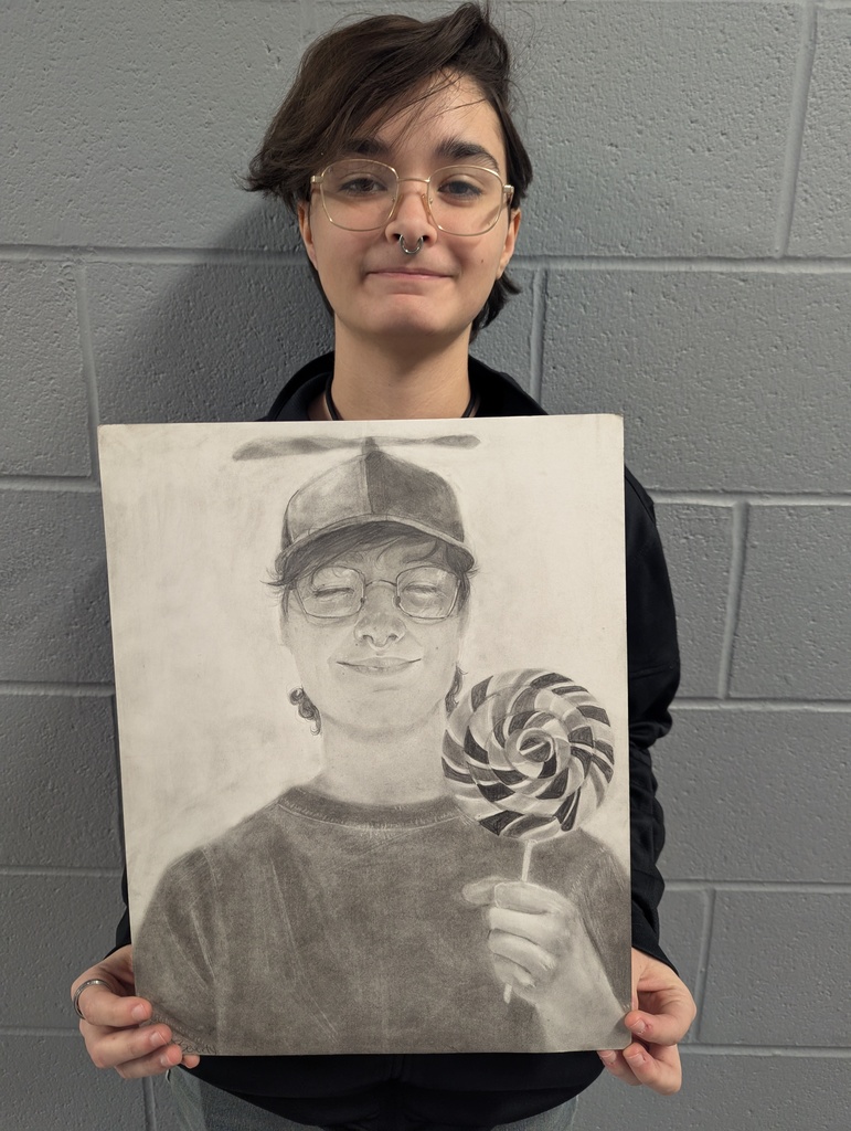 Student holding art work