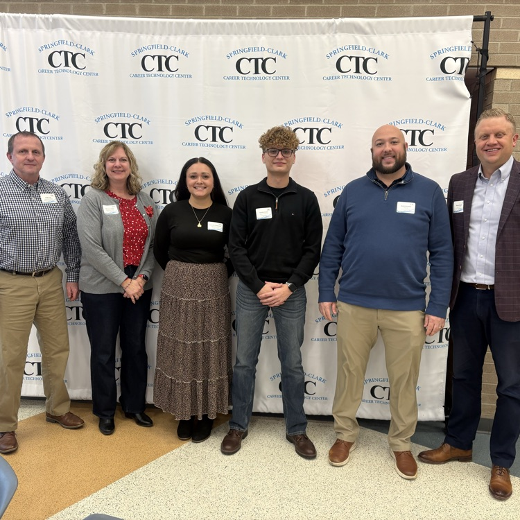 group of board members and students standing in front of backdrop