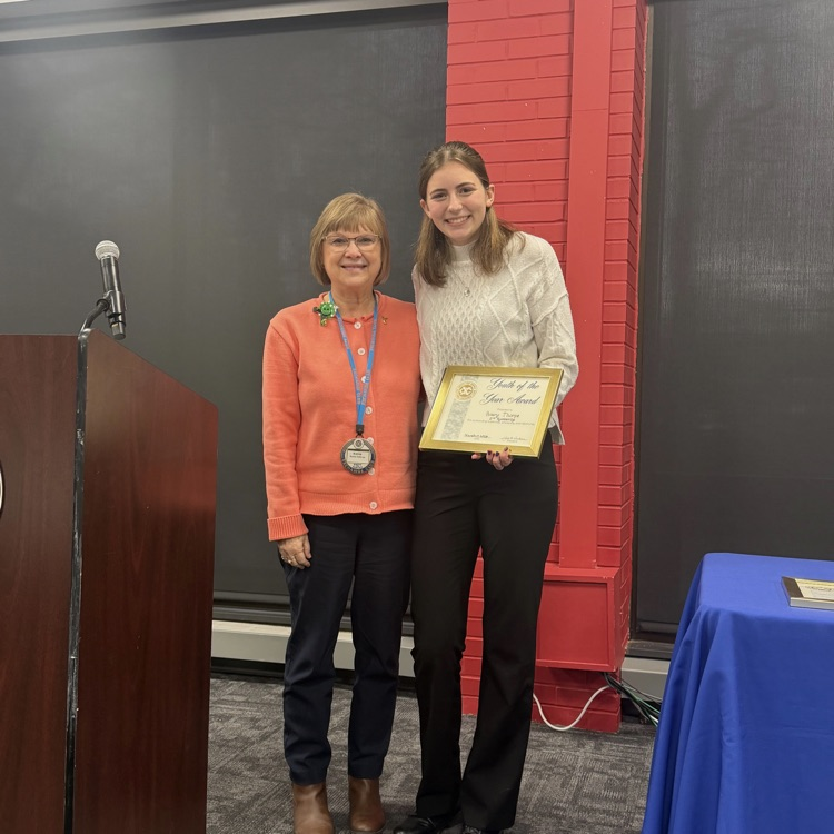 student and adult holding an award