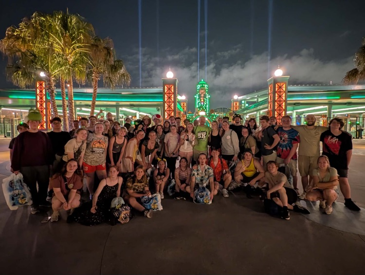 group of students in front of neon lights