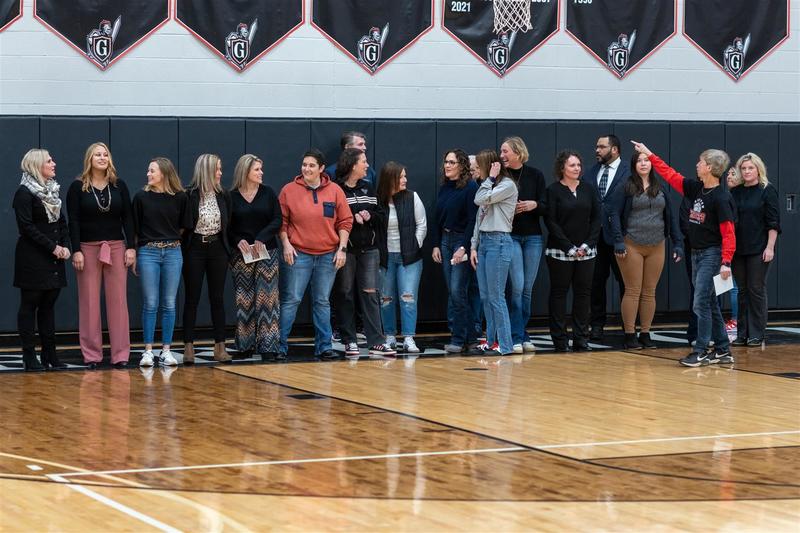 group of women in gym along basketball sidelines