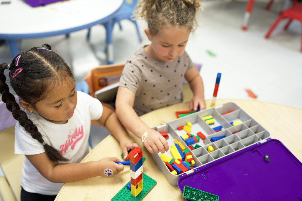 Two young girls building legos.