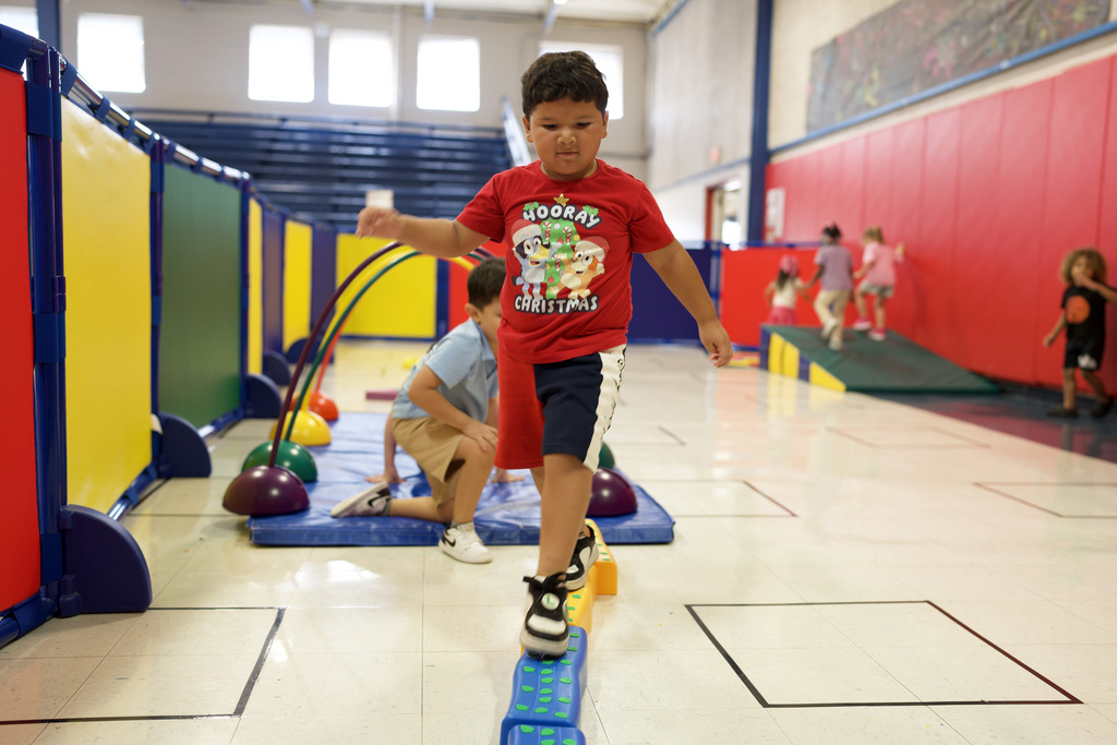 Young boy balancing on a beam.