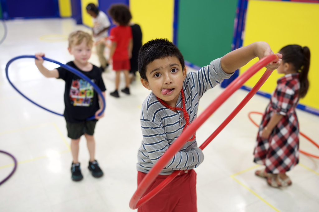 Young boy learning to hula hoop.