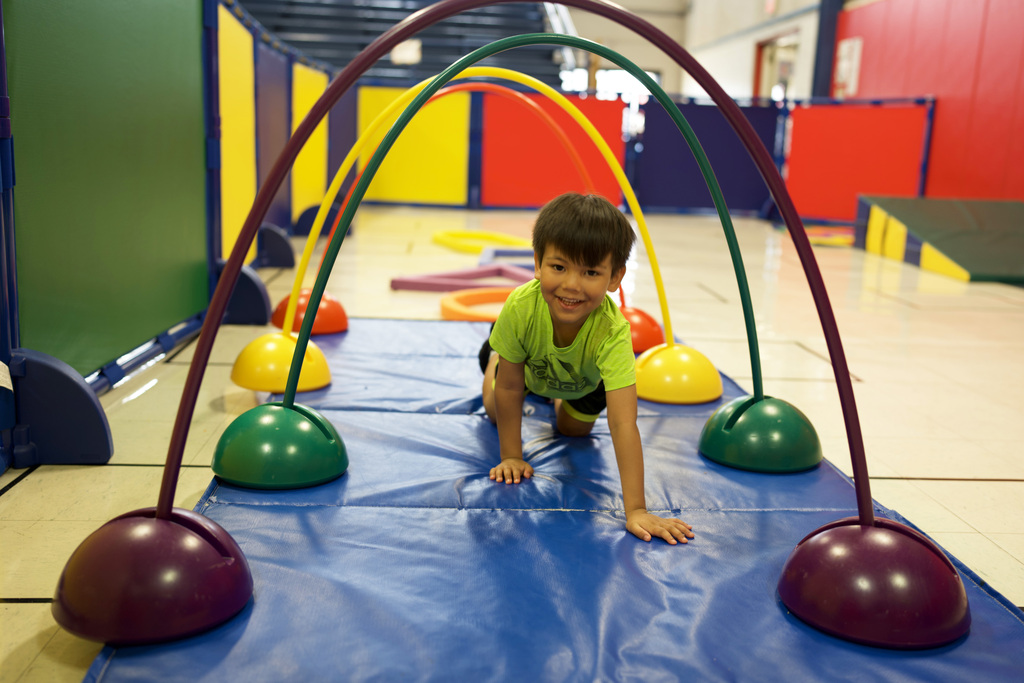 Young boy crawling in arch tunnel.