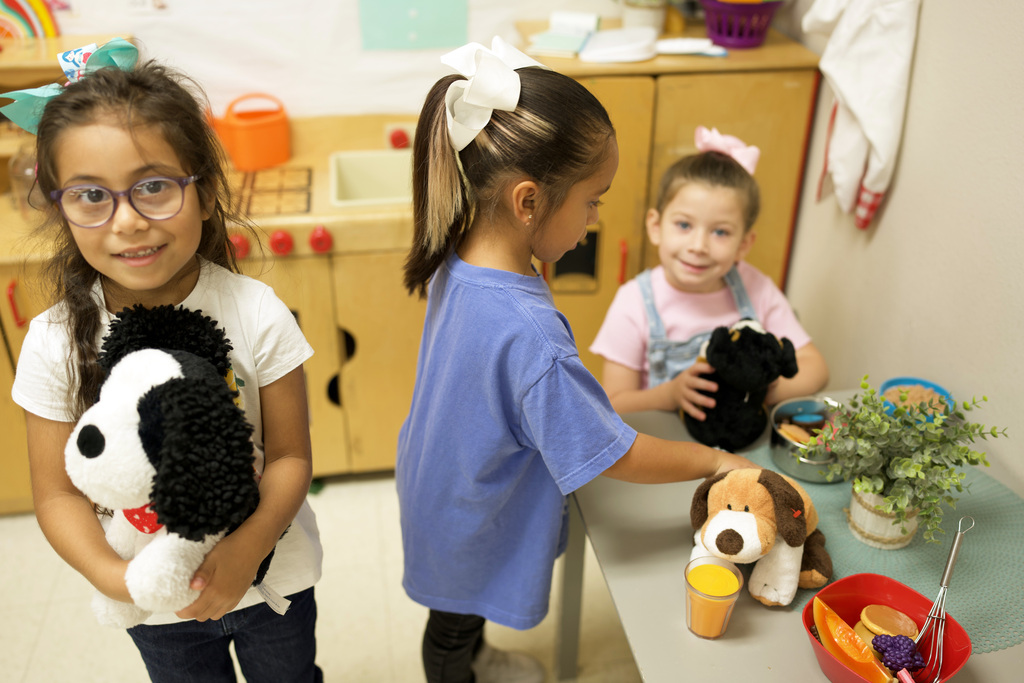 Three young girls playing household.