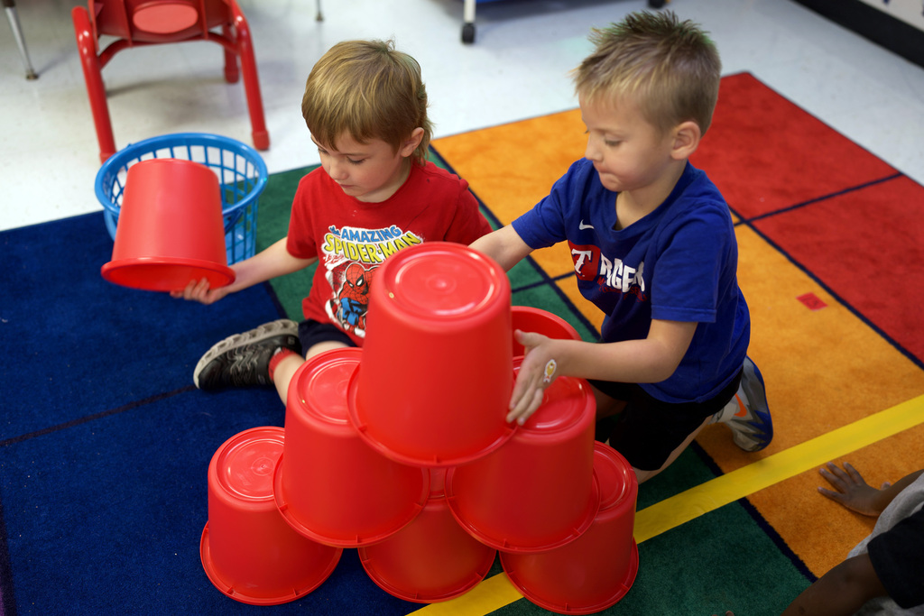 Two young boys building a bucket tower.