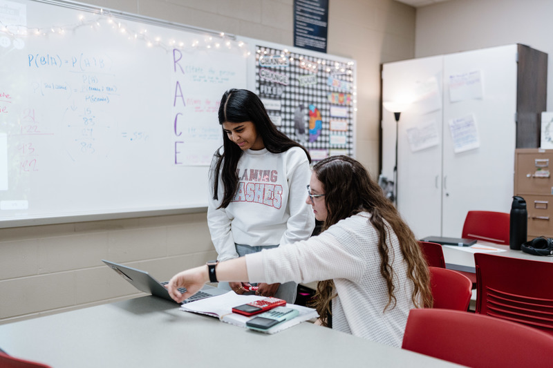 Teacher Showing Student Help on Laptop
