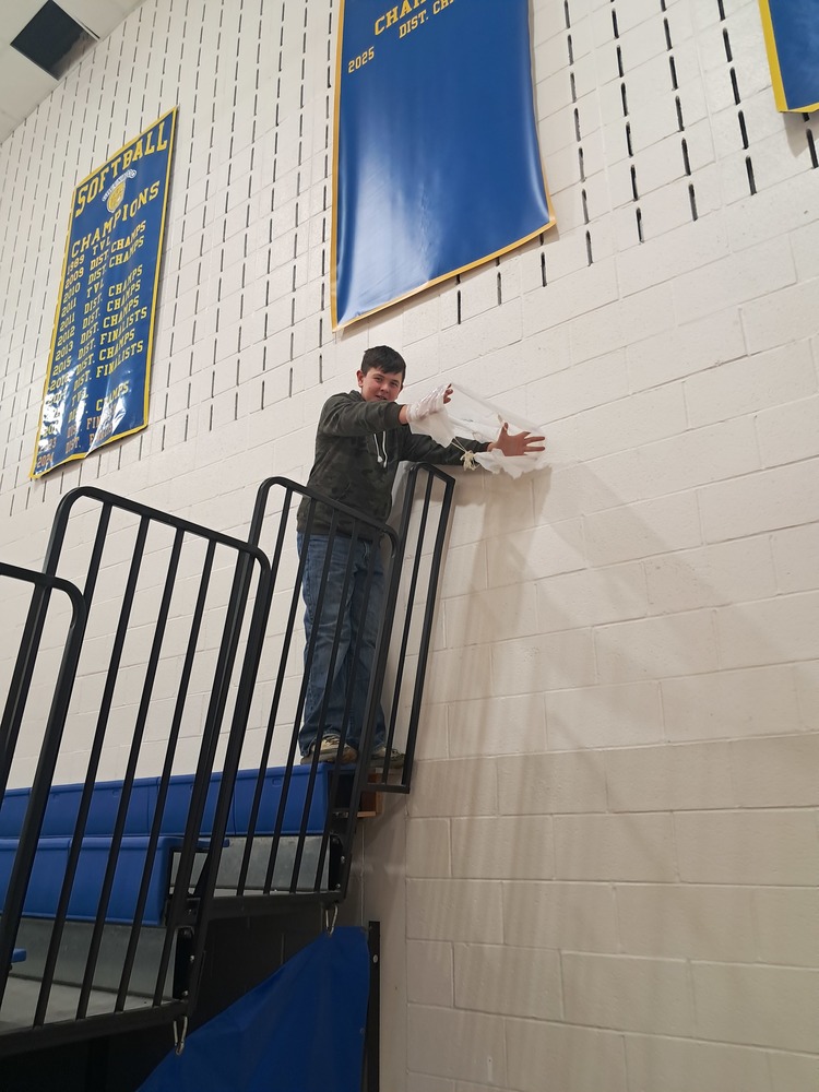 Student dropping a  parachute off of the bleachers