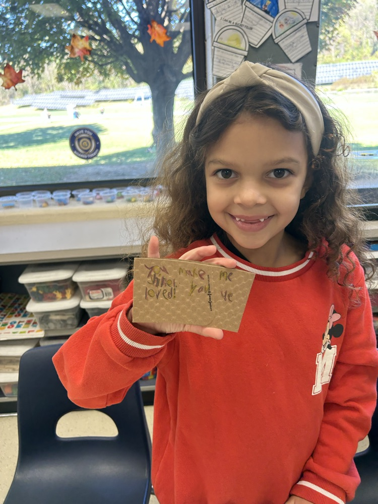 student holding a positive message written on a coffee sleeve for local business shine coffee
