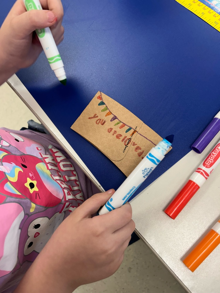 student designed coffee sleeve that says, “you are loved”