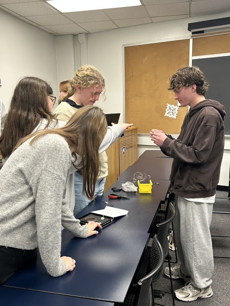 Students learning about fitting microphone headsets for actors.