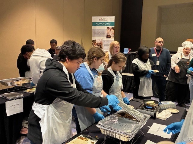Charlie Sheaffer, Shelby Strawser, Taz Dietz, and Grace Peters make Taco Crunchwraps under the direction of chef's at the PRLA Hospitality Career Exploration Workshop.