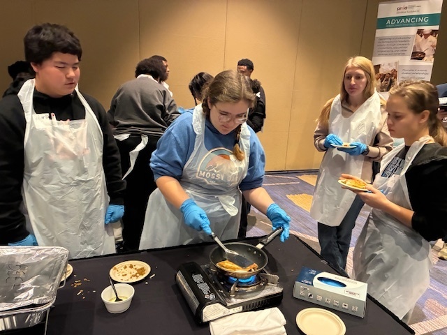 Shelby Strawser grills her taco crunchwrap while Charlie Sheaffer, Taz Dietz, and Grace Peters look on. The students were participating in the PRLA Hospitality Career Exploration Workshop.