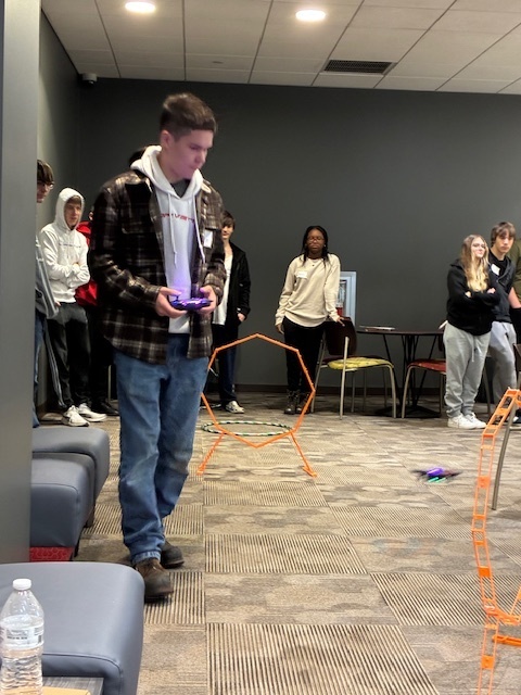 Dalton Trude is flying a drone through a series of obstacles at the GIS Day at Harrisburg University.