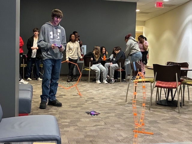 Tyler Moffitt is flying a drone through a series of obstacles at the GIS Day at Harrisburg University.