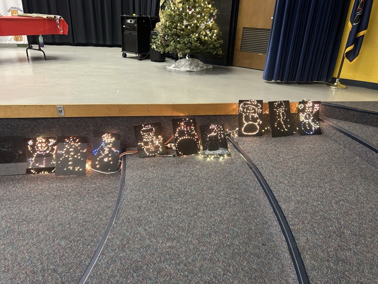 one set of light up snowmen in front of a stage, snowmen have white and bright color lights