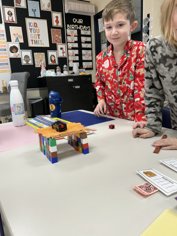 student in red pajamas smiling with his beam bridge 