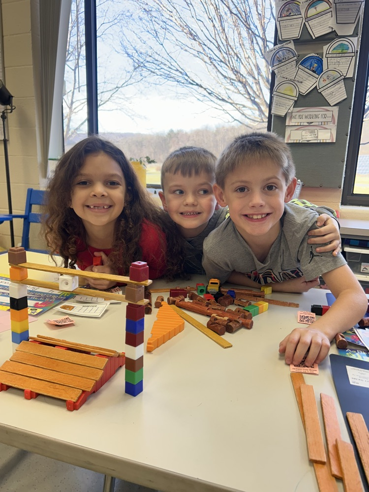 three students smile with their arch bridge and cables 