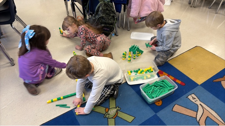 four students work to create a bridge out of base ten blocks 