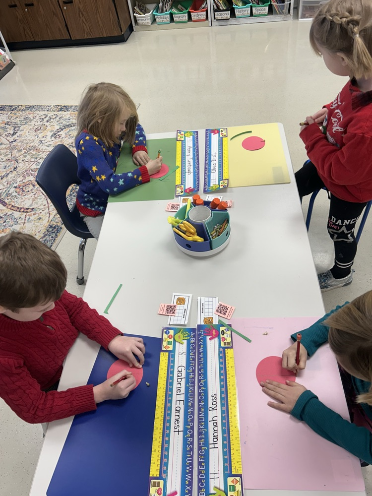 four students creating a compass rose 