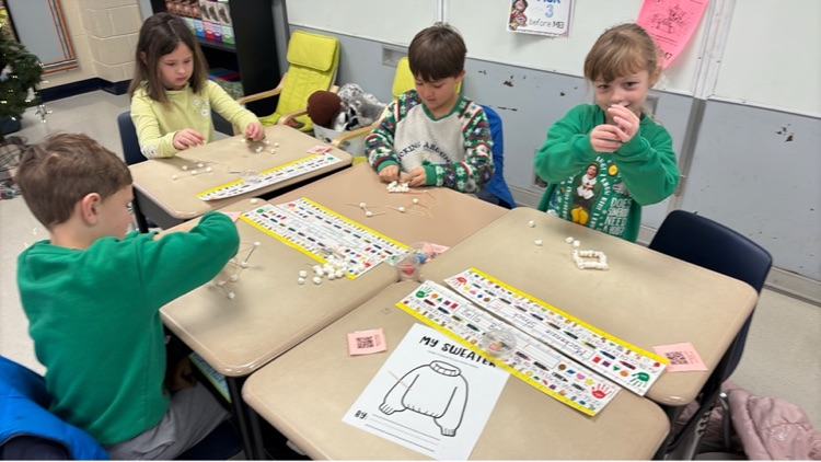 three students work to create individual igloos out of marshmallows and toothpicks 