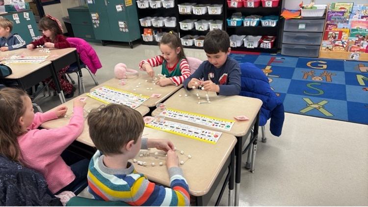 four students work to create individual igloos out of marshmallows and toothpicks 