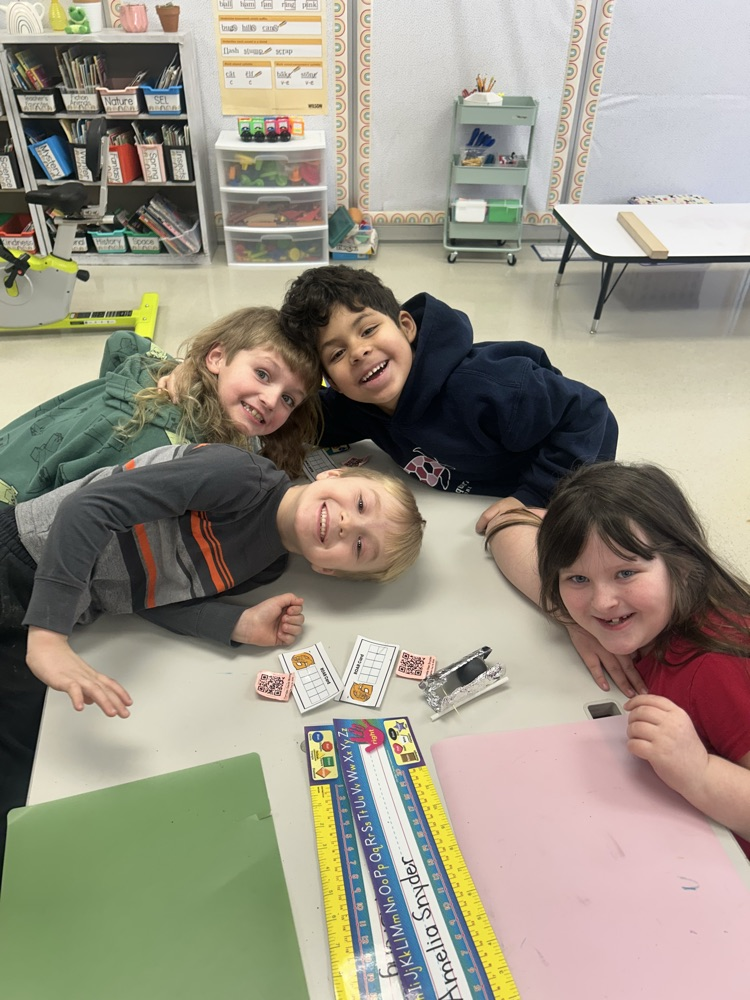 4 students smile at a table around their handcrafted bobsled 