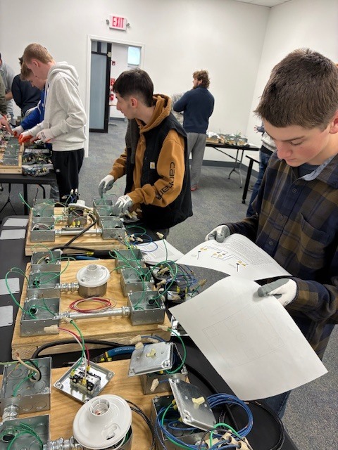 Nate Clark reads the instructions for completing a simulation at IBEW while Blake Harper prepares to complete his next step.
