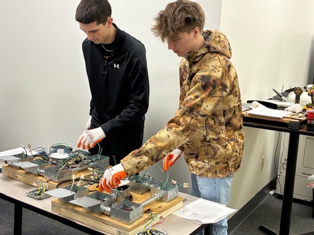 Dylan Womer and Bronson Moyer practice their wiring skills at IBEW.